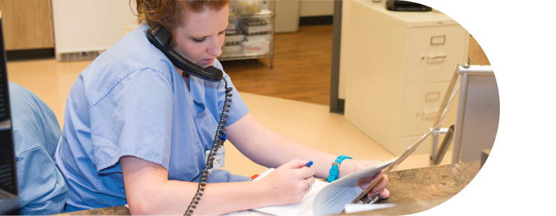 Nurse reviewing insurance paperwork on the phone
